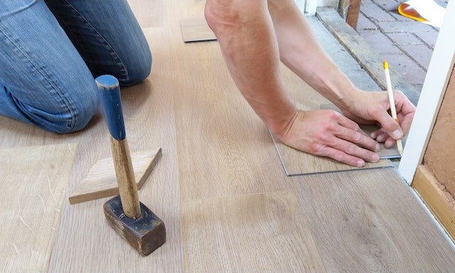 contractor%20measuring%20wood%20flooring%20to%20install%20in%20tight%20corner
